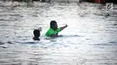 Dua bocah bermain air saat terjadi banjir rob di jalan Yos Sudarso Semarang di kawasan Pelabuhan Tanjung Emas (24/4). Banjir rob ini terjadi karena dipicu oleh salah satunya sistem drainase yang masih kurang baik. (Liputan6.com/Gholib)