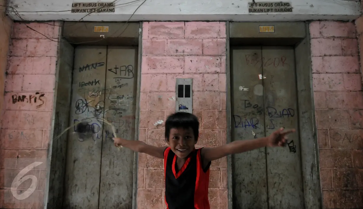 Seorang anak berpose di depan lift yang tidak berfungsi lagi di Rusun Tanah Abang, Jakarta, Senin (4/1/2016). Tahun 2016 Pemprov DKI Jakarta akan membangun 50 rusun bagi warga yang terkena dampak program normalisasi sungai  (Liputan6.com/Johan Tallo)