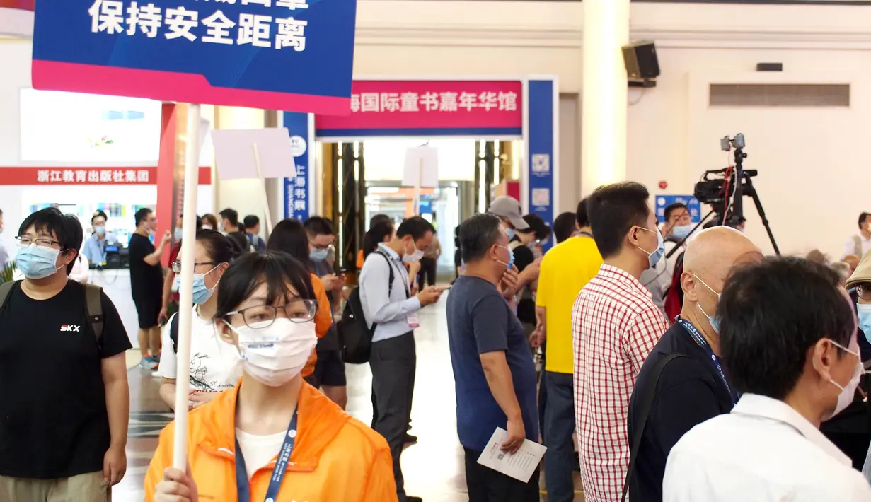 Seorang sukarelawan memegang poster kesadaran epidemi di Pameran Buku Shanghai 2020 di Shanghai, China (12/8/2020). Pameran Buku Shanghai 2020 dimulai 12 dan 18 Agustus harus mendaftar dengan nama asli mereka, menunjukkan kode kesehatan, memakai masker, dan memeriksa suhu. (Xinhua/Ren Long)