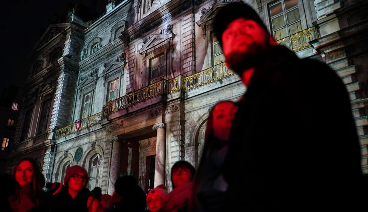 Orang-orang menghadiri pertunjukan cahaya malam di Lyon, Prancis, 8 Desember 2022. Jutaan orang diperkirakan akan menyaksikan acara Festival Cahaya selama empat hari di kota tersebut. (AP Photo/Laurent Cipriani)
