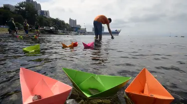Beberapa warga meluncurkan perahu kertas saat perayaan ulang tahun ke-69 akhir Perang Dunia II di Vladivostok, (2/9/2014). (REUTERS/Yuri Maltsev)