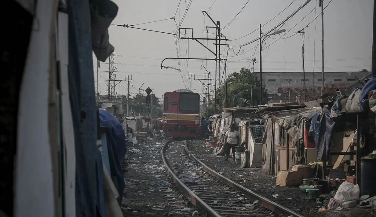 Sebuah kereta terlihat melintas di antara gubuk-gubuk kumuh di bantaran rel kereta api kawasan Senen, Jakarta, (26/9/14). (Liputan6.com/Faizal Fanani)