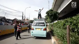 Seorang sopir angkot berorasi dengan menaiki kendaraannya saat unjuk rasa di Jalan Jatibaru, Tanah Abang, Jakarta, Senin (29/1). Para pengunjuk rasa adalah para sopir angkot trayek M08, M10, YP03, M09, M11, dan M9A. (Liputan6.com/Arya Manggala)