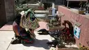 Seorang pria mengenakan kostum dan topeng binatang berdoa di makam kerabatnya saat perayaan tradisional di Naiguata, Venezuela (31/5). Sejumlah orang kerasukan dan menari selama festival yang dikenal Dancing Devils ini di Naiguata. (AP/Arian Cubillos)