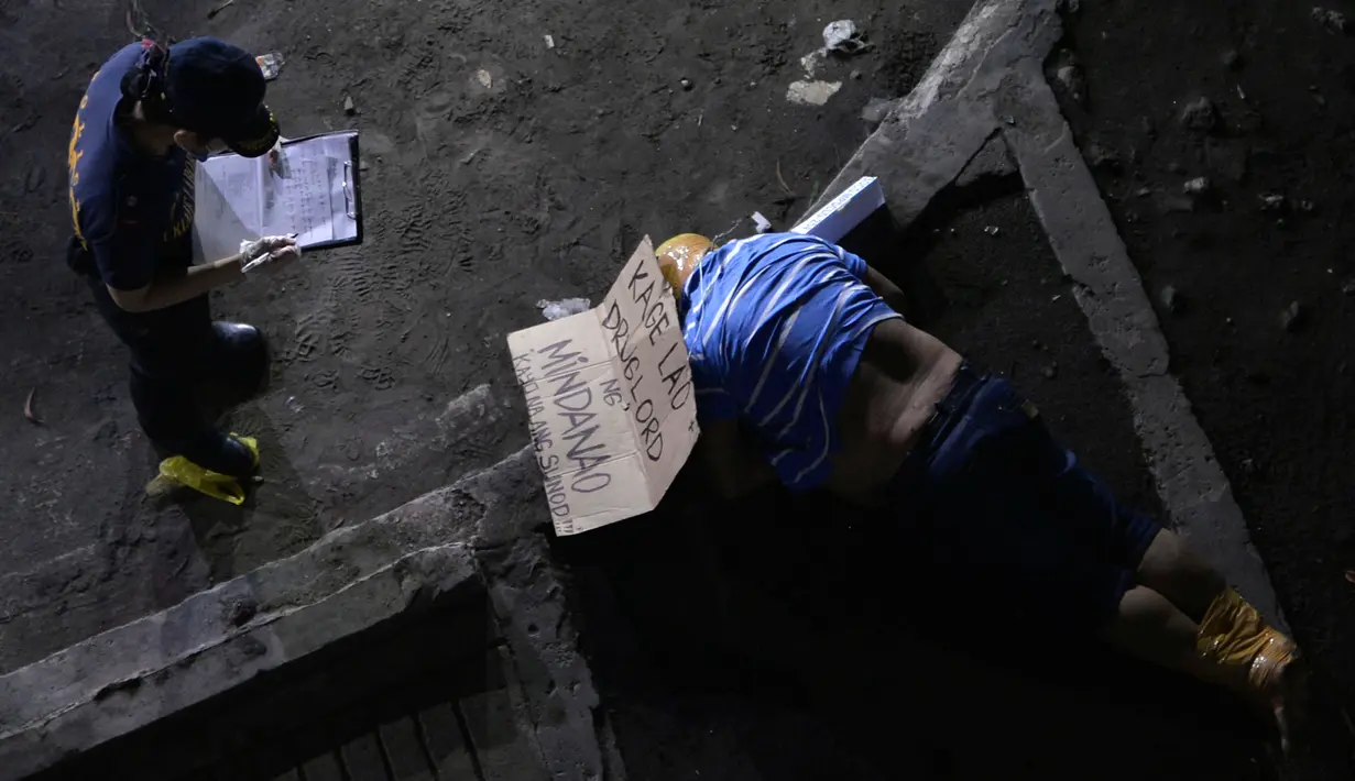 Seorang penyidik polisi berdiri di dekat tubuh pria yang diikat kepala dan kakinya di Manila, Filipina, (21/9). (REUTERS/Ezra Acayan)