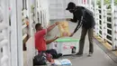 Petugas sharp memberikan kantong berisi makanan dan minuman yang merupakan sumbangan dari warga di Halte Dukuh Atas, Jakarta, Rabu (05/5/2021). Program CSR bertajuk Sharp Bersedekah menempatkan lemari es di area publik seperti lobi perkantoran hingga pusat perbelanjaan.(Liputan6.com/Fery Pradolo)