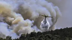 Pesawat pemadam kebakaran Canadair menyemprotkan air saat terjadi kebakaran di Dervenochoria, barat laut Athena, Yunani, 19 Juli 2023. Panas ekstrem diramalkan terjadi di seluruh dunia pada 19 Juli 2023 saat kebakaran hutan berkobar dan peringatan kesehatan diberlakukan di beberapa bagian Asia, Eropa, dan Amerika Utara. (Spyros BAKALIS/AFP)