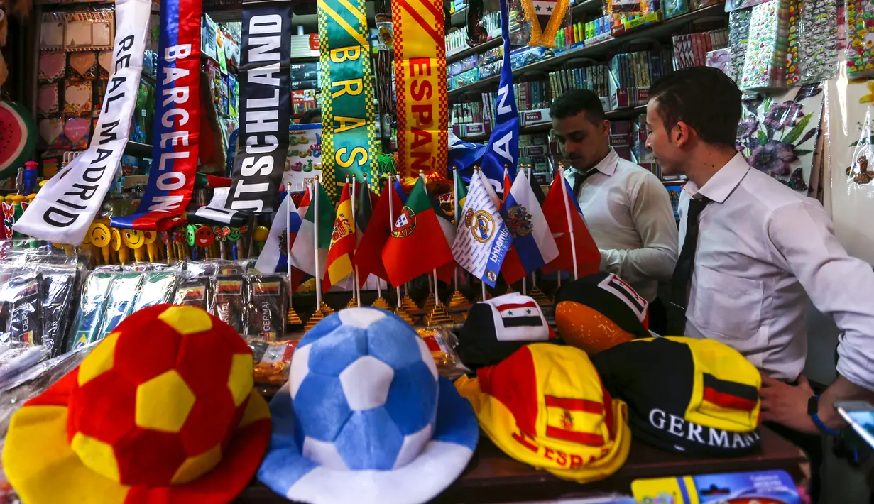 Pembeli mencari pernak-pernik negara-negara yang berpartisipasi pada Piala Dunia FIFA 2018 di jalan pasar di kota tua Damasku, Suriah (6/6). Piala Dunia akan digelar pada 14 Juni 2018 di Rusia. (AFP Photo/Louai Beshara)