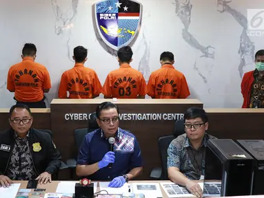 Kabag Penum Divisi Humas Polri Kombes Asep Adi Saputra (tengah) didampingi Kasubdit I Tindak Pidana Siber Bareskrim Polri Kombes (Pol) Dani Kustoni (kiri) menunjukkan tersangka beserta barang bukti kasus tindak pidana hacking server Indomaret di Jakarta, Jumat (12/4). (Liputan6.com/ImmanuelAntonius)