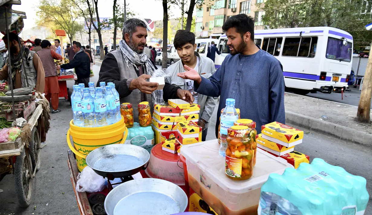 Dalam gambar yang diambil pada 5 April 2022, pelanggan membeli makanan berbuka puasa untuk berbuka puasa di pasar selama bulan suci Ramadhan di Kabul, Afghanistan. (Sahel ARMAN / AFP)