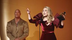 Adele saat menerima penghargaan Best Pop Solo Performance untuk lagu "Easy On Me," di atas panggung selama Grammy Awards 2023 di Crypto.com Arena di Los Angeles, California pada 5 Februari 2023. Berjumpa dengan Dwayne Johnson alias The Rock , Adele benar-benar sangat bahagia. (Frazer Harrison/Getty Images/AFP)
