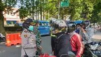 Aparat gabungan memeriksa pengendara roda dua saat penerapan PSBB corona di Kota Bogor. (Achmad Sudarno/Liputan6.com)