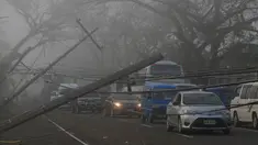Sejumlah kendaraan melewati tiang listrik yang roboh akibat angin kencang yang disebabkan Topan Nock-ten di kota Pili, Camarines sur, Filipina tengah (27/12). Topan Nock-ten atau dikenal dengan Nina menerjang Filipina saat Natal. (REUTERS/Romeo Ranoco)