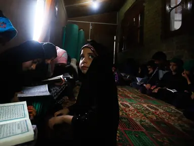 Anak-anak Muslim Kashmir menghadiri kelas membaca Alquran pada bulan ramadan di Srinagar, Kashmir yang dikuasai India, 7 Mei 2019. Saat ini umat Islam di seluruh dunia sedang menjalankan ibadah di bulan Ramadan dengan menahan lapar, haus, dan hawa nafsu mulai fajar hingga senja. (AP/Mukhtar Khan)