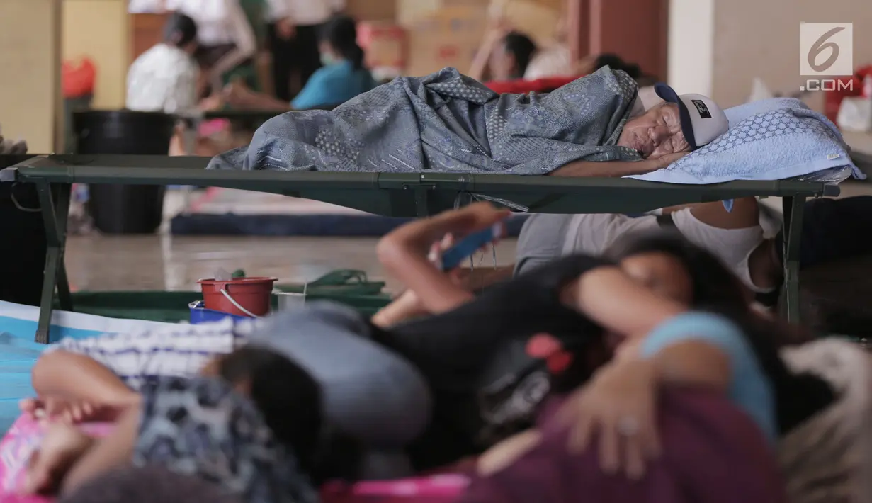 Pengungsi Gunung Agung tidur di tempat penampungan sementara di Gor Swecapura, Klungkung, Bali, Sabtu (30/9). Pemerintah Kabupaten Klungkung mendata ulang pengungsi yang ada. (Liputan6.com/Gempur M Surya)