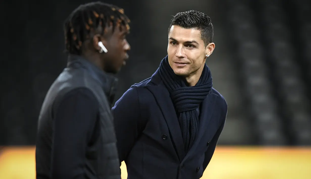 Penyerang Juventus, Cristiano Ronaldo bersama rekannya Moise Kean memeriksa lapangan di Stade de Suisse di Bern (11/12). Juventus akan bertanding melawan Young Boys pada lanjutan grup H Liga Champions. (AFP Photo/Fabrice Coffrini)