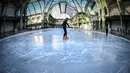 Pengunjung menikmati berseluncur di arena ice skating di bawah kubah kaca mewah legendaris, Grand Palais, Paris, Senin (17/12). Tempat seluas 1.800 meter persegi ini menjadi arena ice skating sementara terbesar di Prancis. (STEPHANE DE SAKUTIN / AFP)
