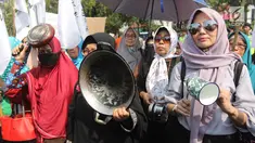 Sejumlah ibu-ibu yang tergabung dalam Barisan Emak-Emak Militan (BE2M) Indonesia menggelar aksi di seberang Istana Merdeka, Jakarta, Rabu (18/7). Mereka menuntut Presiden Jokowi menurunkan harga sembilan bahan pokok (sembako). (Liputan6.com/Arya Manggala)