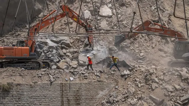 Pekerja menggali puing-puing terowongan yang runtuh di Distrik Ramban, selatan Srinagar, Kashmir yang dikuasai India, Jumat, 20 Mei 2022. (Foto AP/Dar Yasin)