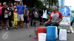 Pengamen perkusi sedang beraksi ditonton para pengunjung saat CFD, Jakarta, Minggu (10/9). Di sepanjang jalan lokasi CFD terdapat aneka kegiatan seperti olahraga, berjualan dan  mengamen. (Liputan6.com/Gempur M. Surya)