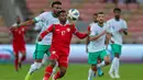Pemain Oman Arshad al-Alawi (tengah) dibayangi pemain Arab Saudi Ali al-Bulaihi (kiri) pada pertandingan sepak bola Kualifikasi Piala Dunia 2022 di Stadion King Abdullah Sport City, Jeddah, Arab Saudi, 27 Januari 2022. Arab Saudi menang 1-0. (AFP)