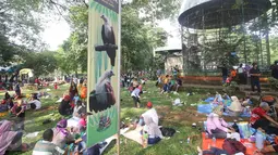 Sejumlah pengunjung menggelar tikar di depan kandang burung saat wisata ke Taman Margasatwa Ragunan, Jakarta, Kamis (7/7). Sampai pukul 15.00 WIB, jumlah pengunjung Ragunan pada hari kedua Lebaran ini sekitar 104.000 orang (Liputan6.com/Immanuel Antonius)