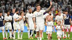 Pemain Real Madrid, Toni Kroos (tengah) bersama anak-anaknya saat melakukan perpisahan setelah laga Liga Spanyol 2023/2024 melawan Real Betis di Santiago Bernabeu, Madrid, Spanyol, Minggu (26/05/2024) dini hari WIB. Kroos memutuskan untuk pensiun dari sepak bola setelah Euro 2024 nanti. (AFP/Javier Soriano)