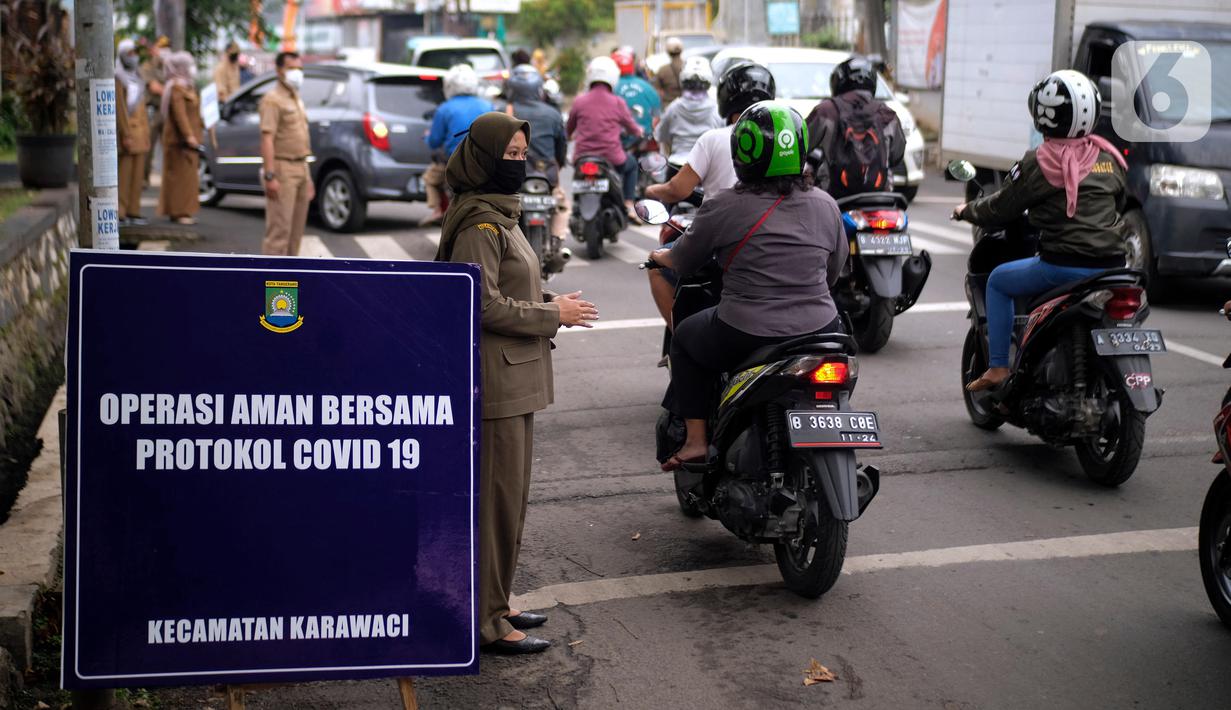 Petugas merazia warga yang tidak mengenakan masker di Kelurahan Cimone, Kota Tangerang, Banten, Rabu (15/7/2020). Guna memberi efek jera, Pemkot Tangerang memberlakukan sanksi sosial kepada pelanggar PSBB seperti menyapu dengan memakai rompi bertulis ‘Pelanggar PSBB’. (Liputan6.com/Angga Yuniar)