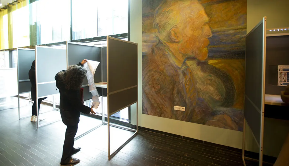Seorang pemilih membuka surat suaranya saat memberikan suara dalam pemilihan umum di Museum Van Gogh, Amsterdam, Belanda, Rabu (17/3/2021). Pemilu digelar selama tiga hari untuk memungkinkan warga memilih dengan aman selama pandemi virus corona COVID-19. (AP Photo/Peter Dejong)