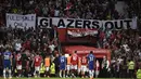 Spanduk bertuliskan "Glazer Out" terpampang di salah satu sisi stadion Old Trafford dalam laga tunda pekan ke-32 Liga Inggris 2022/2023 antara MU melawan Chelsea, Jumat (26/5/2023). (AFP/Oli Scarff)