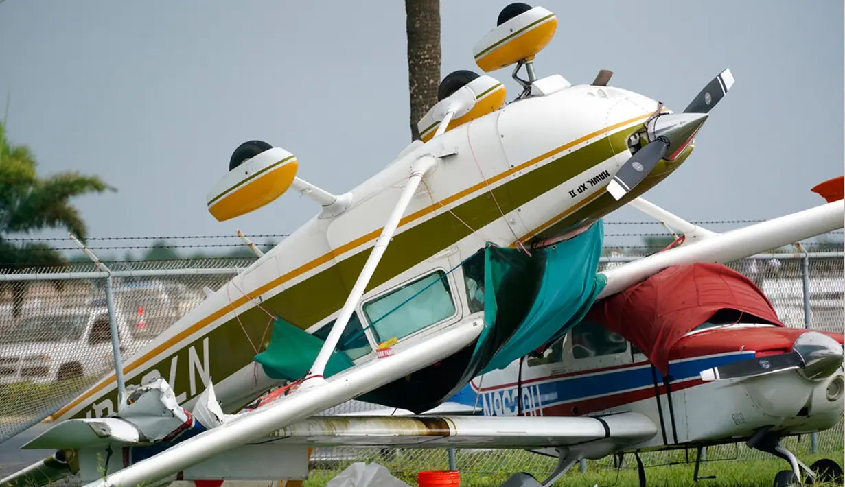 Sebuah pesawat terbalik kemungkinan karena tornado yang dihasilkan dari Badai Ian di Bandara Perry Utara, Pembroke Pines, Florida, 28 September 2022. Kecepatan Badai Ian meningkat saat mendekati daratan di sepanjang pantai barat daya Florida. (AP Photo/Wilfredo Lee)