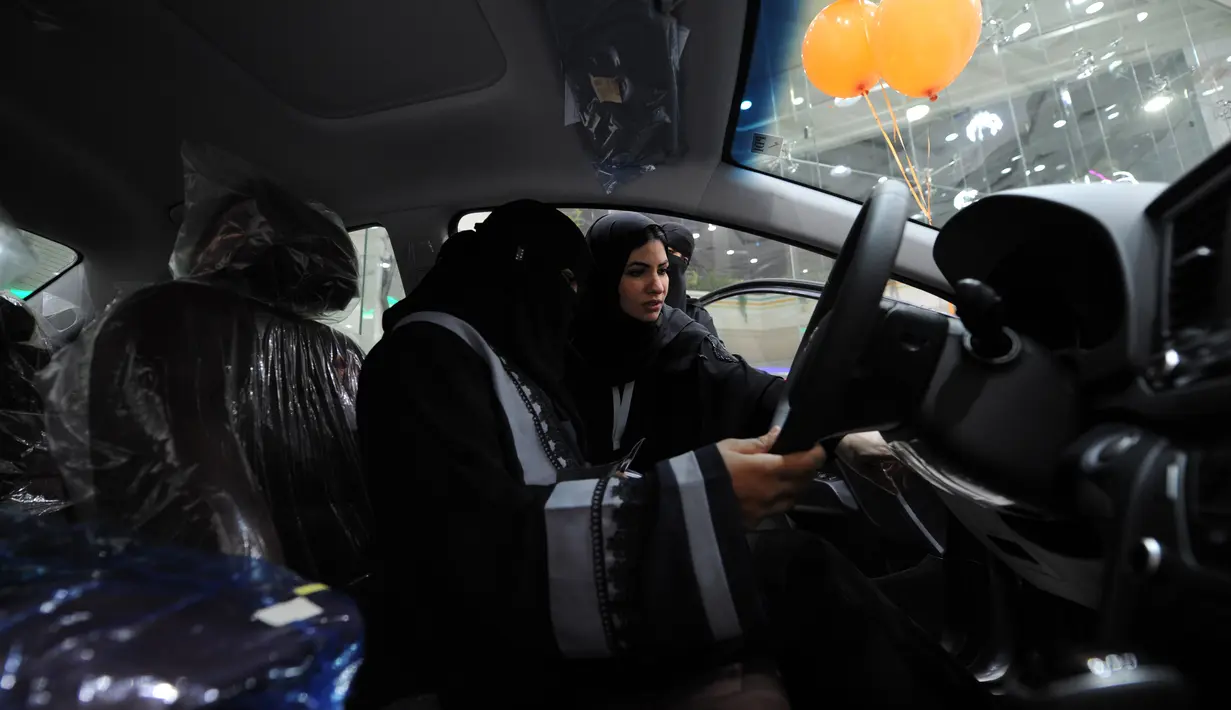 Perempuan Arab Saudi menjajal mobil saat mengunjungi showroom mobil khusus wanita di kota pelabuhan Laut Merah, Jeddah, Kamis (11/1). Showroom ini juga menawarkan solusi pembiayaan bagi perempuan yang akan membeli mobil tersebut. (Amer HILABI/AFP)