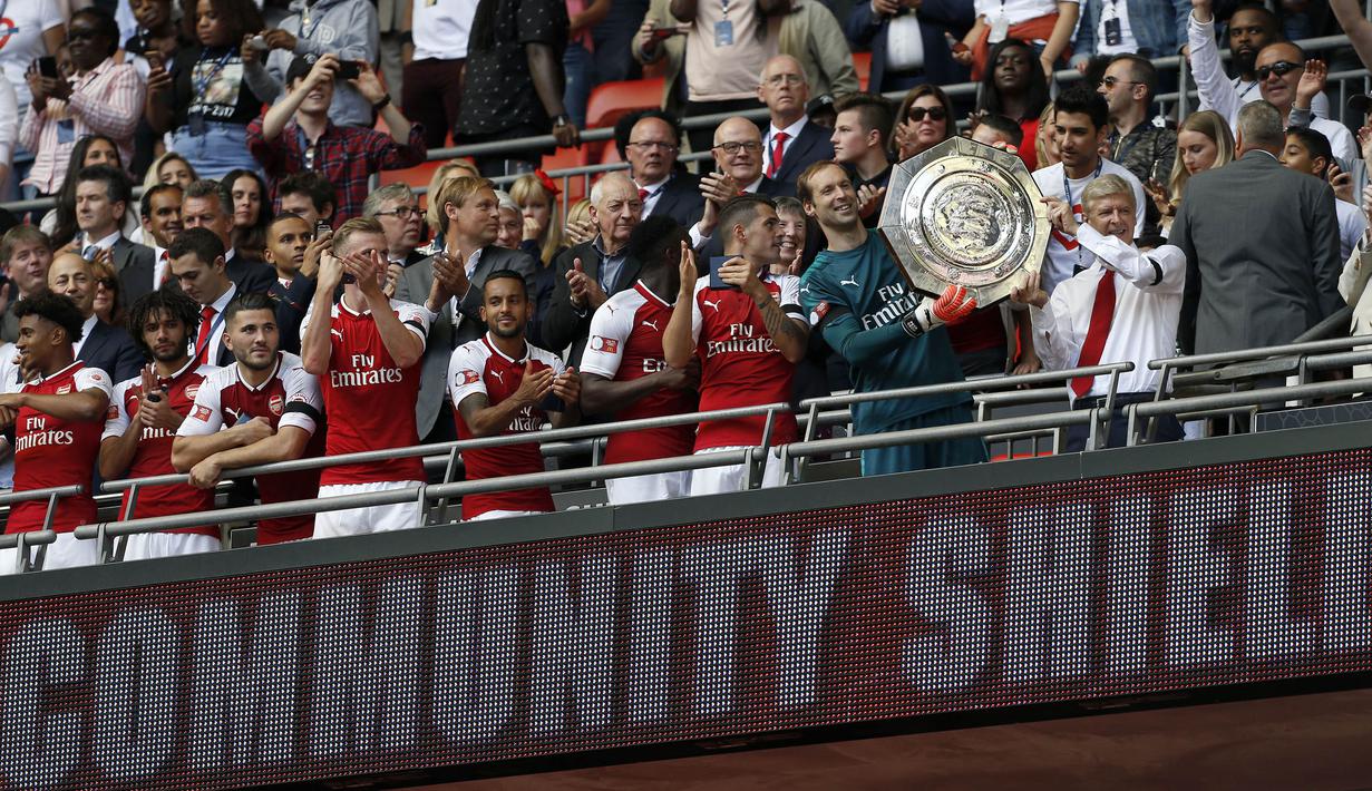 Pelatih Arsenal, Arsene Wenger, bersama para pemainnya menerima trofi Community Shield usai mengalahkan Chelsea di Stadion Wembley, London, Minggu (6/8/2017). Ini merupakan trofi Community Shield yang ke-15 bagi Arsenal. (AFP/Ian Kington)