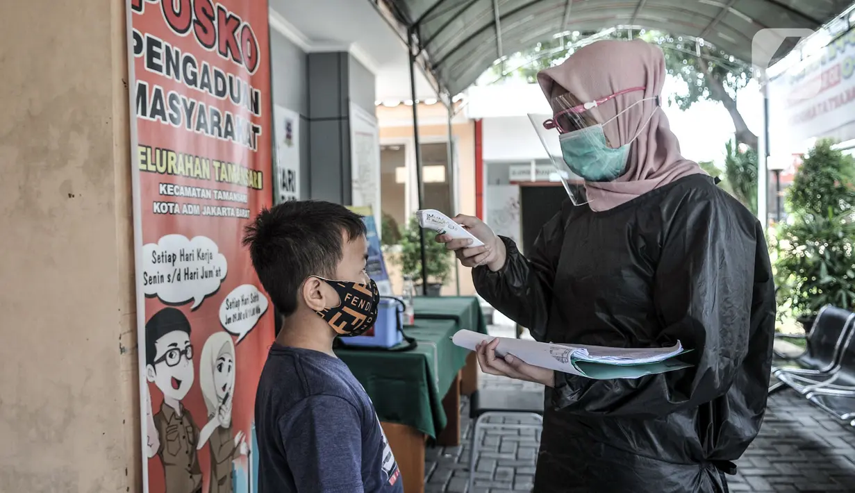 Petugas paramedis memeriksa suhu tubuh salah seorang anak sebelum mengikuti program BIAS di Kantor Kelurahan Tamansari, Jakarta, Selasa (24/11/2020). BIAS dilakukan dengan konsisten menerapkan protokol kesehatan COVID-19. (merdeka.com/Iqbal S. Nugroho)
