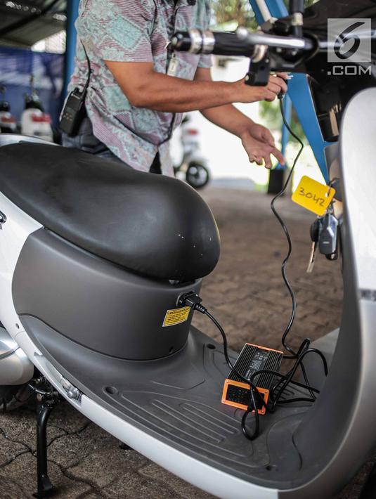 Petugas menunjukan pengisian daya motor listrik di Taman Marga Satwa Ragunan, Jakarta, Kamis (13/12). Pemprov DKI mulai menggunakan motor listrik di beberapa titik untuk mempercepat penggunaan kendaraan listrik di Indonesia. (Liputan6.com/Faizal Fanani)
