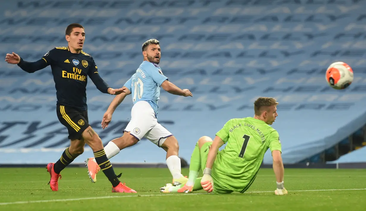 Pemain Manchester City Sergio Aguero (tengah) mencungkil bola melewati kiper Arsenal Jerman Bernd Leno (tengah) pada laga Premier League di Etihad Stadium, Manchester, Inggris, Rabu (17/6/2020). Manchester City menang dengan skor 3-0. (PETER POWELL/POOL/AFP)