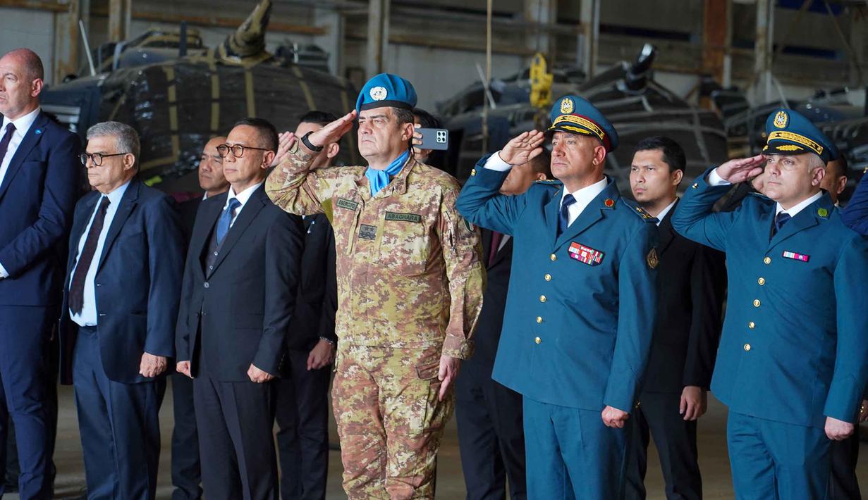 Upacara yang digelar Bandara Internasional Lebanon, Beirut, pada 26 April 2026, dipimpin langsung oleh Kepala Misi dan Komandan UNIFIL, Mayor Jenderal Diodato Abagnara. Tampak dalam foto yang diambil dan dirilis oleh Pasukan Sementara Perserikatan Bangsa-Bangsa di Lebanon (UNIFIL), menunjukkan Duta Besar Indonesia untuk Lebanon Dicky Komar (ketiga kiri), Kepala Misi dan Komandan Pasukan Mayor Jenderal Diodato Abagnara (keempat kiri) dan Menteri Pertahanan Nasional Lebanon dan Angkatan Darat Lebanon, Brigadir Jenderal Maroun Azzi (kedua kanan) memberi hormat untuk jenazah Kopral Rico Pramudia, saat upacara penghormatan di Bandara Internasional Lebanon, Beirut, pada 26 April 2026. (Haidar Fahs/UNIFIL/AFP)