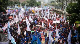 Massa buruh memadati sebagian ruas Jalan Medan Merdeka Barat saat perayaan hari Buruh Internasional di Kawasan Patung Patung Arjuna Wiwaha, Jakarta, Senin (5/1). Ribuan massa buruh ikut dalam perayaan MayDay 2017. (Liputan6.com/Helmi Fithriansyah)