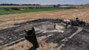 Para petani menyemprotkan air di ladang pertanian yang terbakar di dekat proyektil rudal yang jatuh di dekat kota Najha, Suriah, Senin 8 Juni 2026. (AP Photo/Ghaith Alsayed)