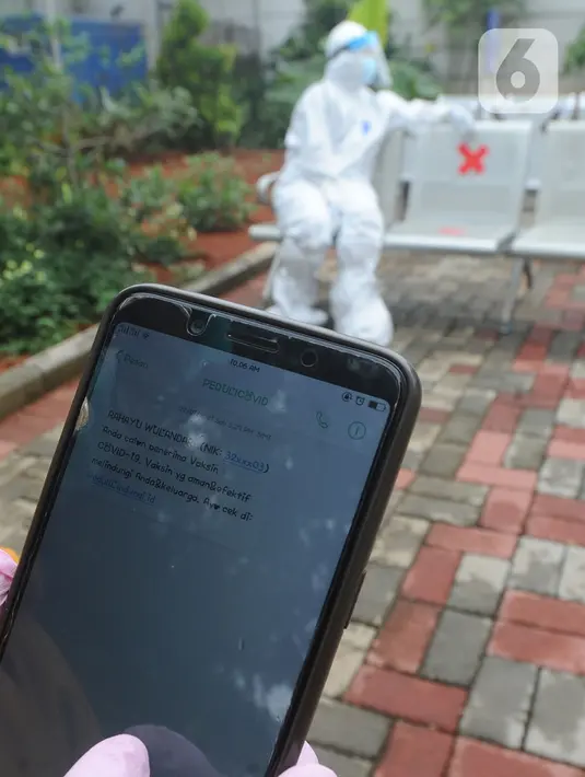 Paramedis menunjukkan SMS undangan mengikuti kegiatan vaksin Covid-19 di Puskesmas  Ciganjur, Jakarta Selatan, Kamis (7/1/2021). Menkes Budi mengharapkan sebelum masyarakat kembali bekerja pada Januari, program vaksinasi terhadap tenaga kesehatan sudah bisa dimulai. (merdeka.com/Arie Basuki)
