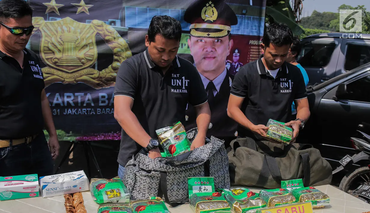 Petugas kepolisian merapikan barang bukti sabu saat rilis kasus narkotika jaringan Internasional Malaysia-Indonesia di Polres Jakarta Barat, Selasa (16/7/2019). Polisi berhasil mengamankan Empat tersangka. (Liputan6.com/Faizal Fanani)