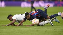 Pemain Real Madrid, Aurelien Tchouameni (kiri) berebut dengan pemain Barcelona, Ansu Fati pada laga leg pertama semifinal Copa Del Rey 2022/2023 di Santiago Bernabeu, Madrid, Jumat (03/03/2023) WIB. Laga berakhir dengan skor 1-0 untuk kemenangan Barcelona. (AFP/Oscar Del Pozo)
