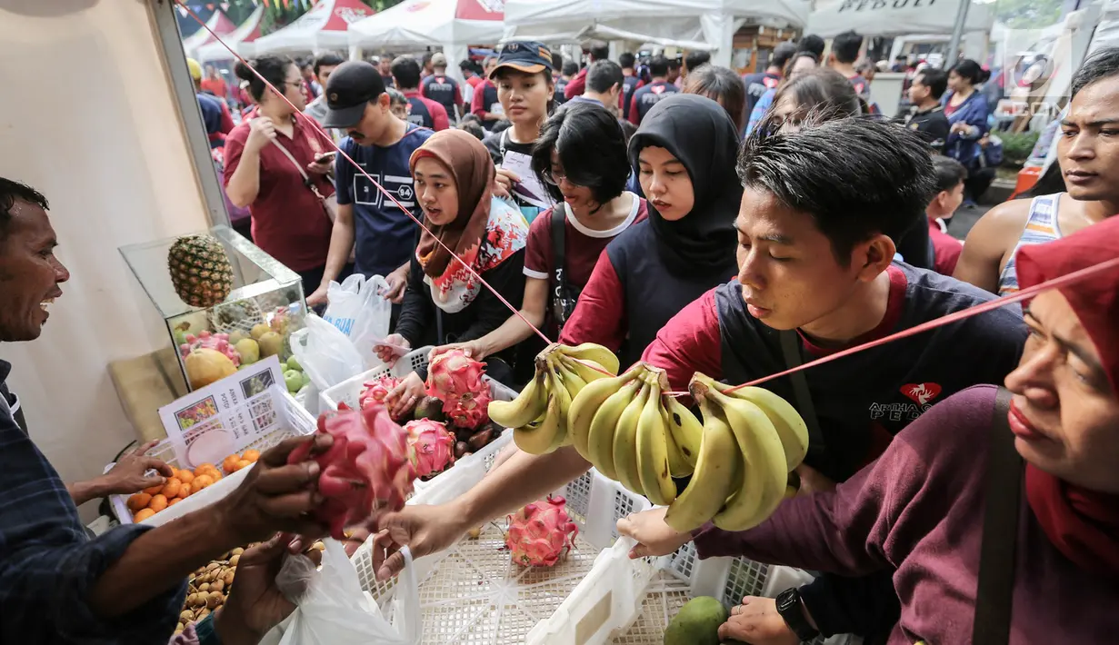 Warga membeli buah-buahan murah pada acara Family Day Artha Graha Peduli (AGP) di Pasar Akhir Pekan SCBD, Jakarta, Minggu (25/11). Acara ini diawali dengan fun walk dan fun run yang diikuti 5000 peserta. (Liputan6.com/Fery Pradolo)
