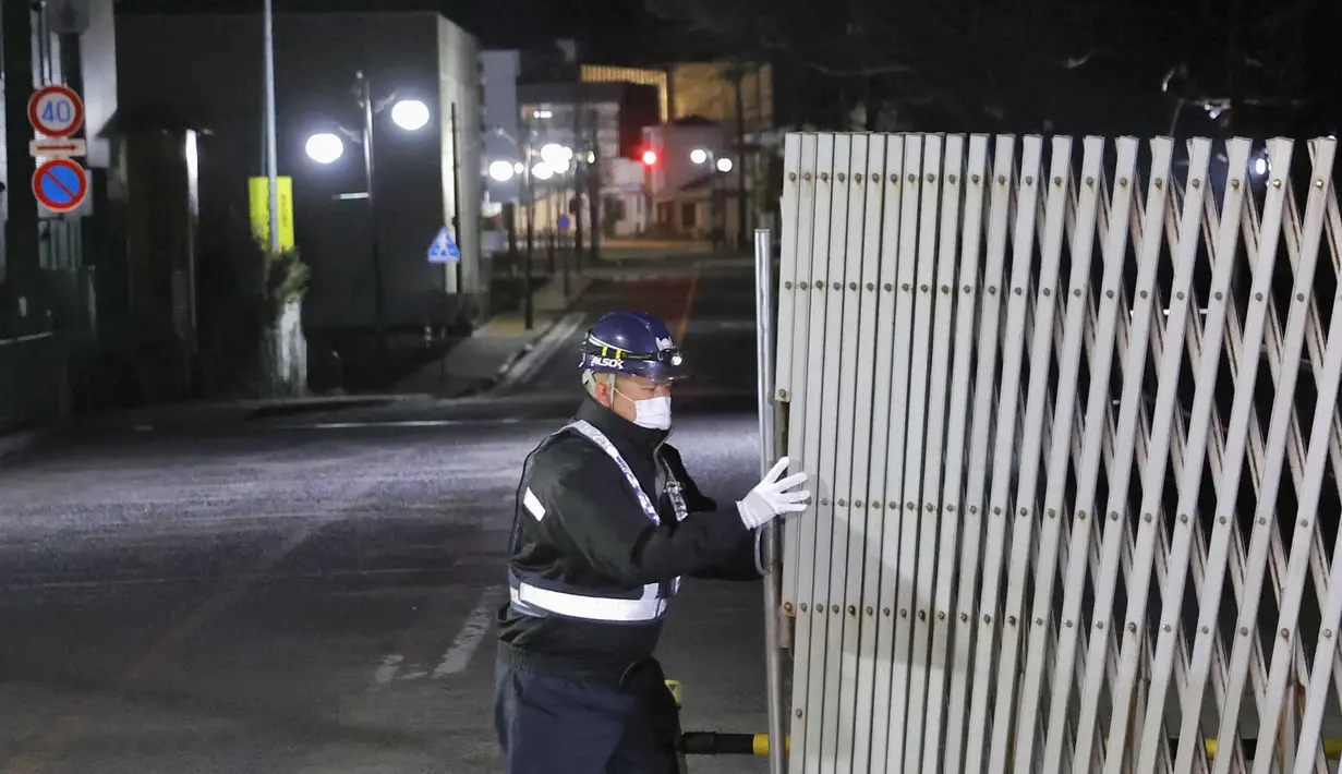 Petugas membuka gerbang ke kota Futaba, prefektur Fukushima, Jepang utara, Rabu (4/3/2020). Pemerintah Jepang mencabut sebagian larangan masuk kota Futaba yang menjadi lokasi terlarang akibat bencana nuklir Fukushima sembilan tahun lalu. (Naoya Osato/Kyodo News via AP)