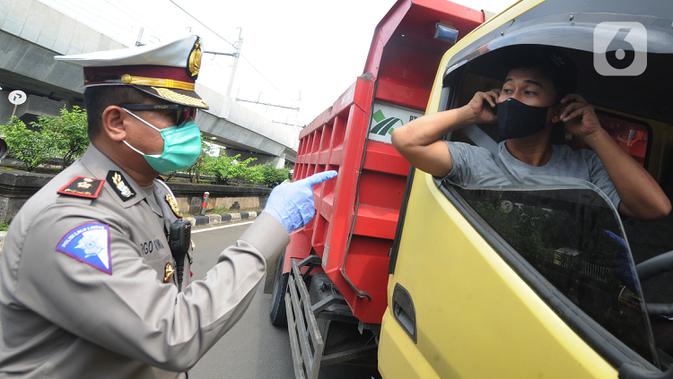 Petugas menyuruh pengemudi truk mengenakan masker saat kegiatan Check Point Pengawasan Pelaksaanaan PSPBB di Jakarta selatan, Jumat (10/4/2020). Kegiatan gabungan Dishub dan Polda Metro Jaya menyasar pengemudi kendaraan bermotor yang tidak menggunakan masker. (merdeka.com/Arie Basuki)