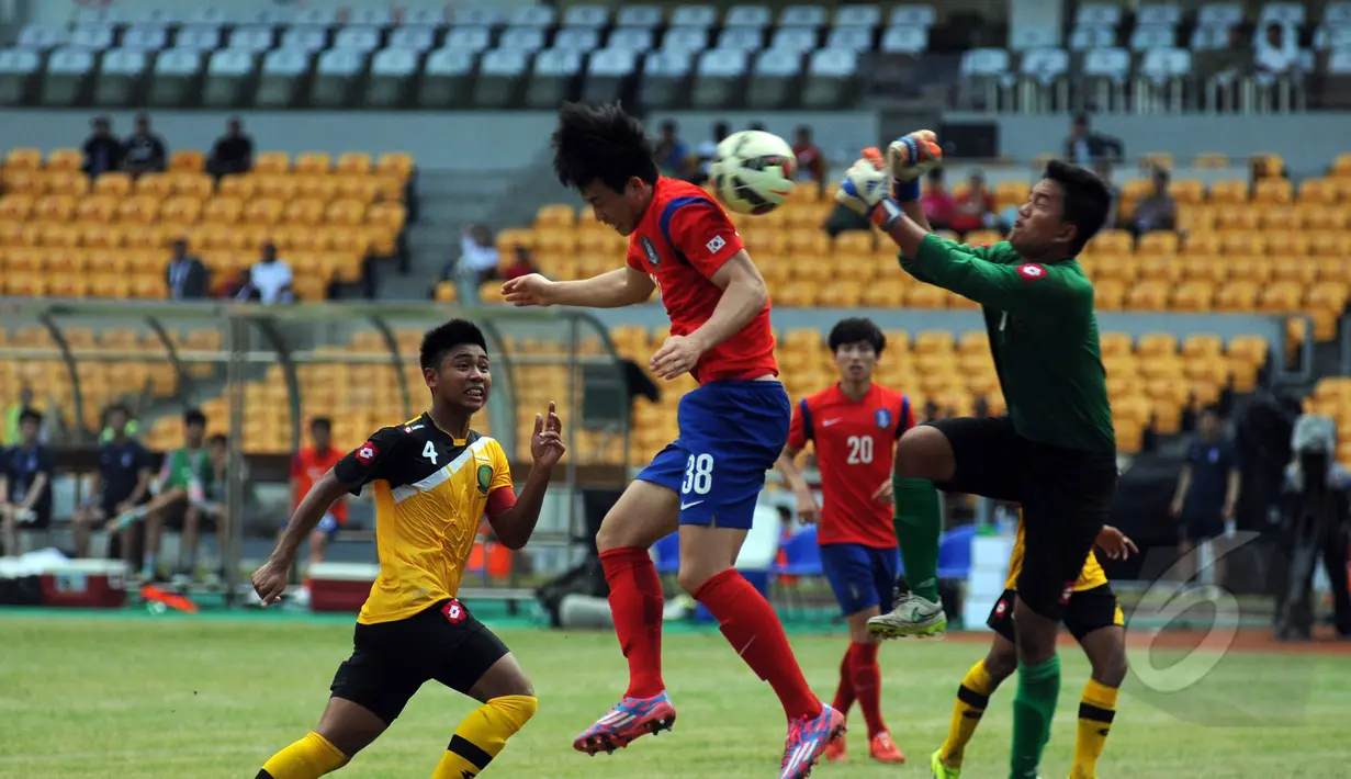 Penjaga gawang Brunei Darussalam U-23, Ahsanuddin (kanan) mencoba menghalau bola saat berlaga melawan Korea Selatan di kualifikasi grup H Piala Asia 2016 di Stadion GBK, Jakarta, Jumat (27/3/2015). (Liputan6.com/Helmi Fithriansyah)