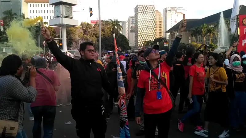 Massa Buruh Menyalakan Kembang Api Sebagai Tanda Berakhirnya Peringatan May Day 2019 di kawasan Patung Kuda, Jakarta, Rabu (1/5/2019). Foto: (Merdeka.com)