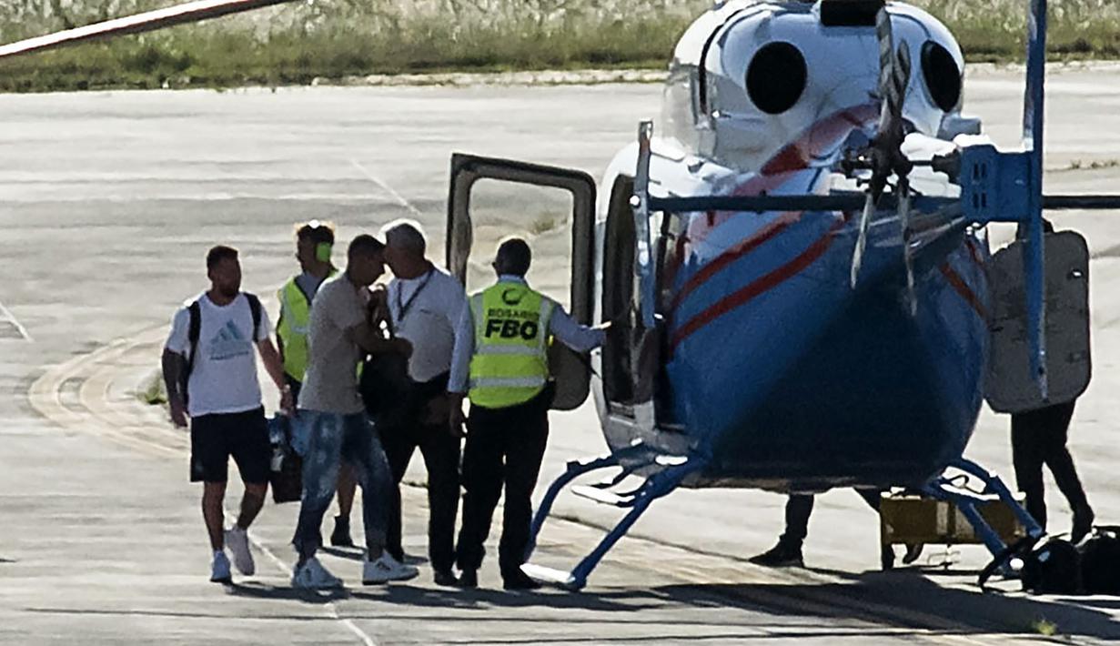 <p>Pemain Argentina, Lionel Messi (kiri) dan Angel Di Maria terlihat berjalan memasuki helikopter saat parade kemenangan Piala Dunia 2022 di provinsi Buenos Aires, pada 20 Desember 2022. Messi dan kolega terpaksa dievakuasi karena bus yang mereka gunakan tak bisa mencapai lokasi yang direncanakan akibat membeludaknya warga di jalanan. (AFP/Matias Baglietto)</p>