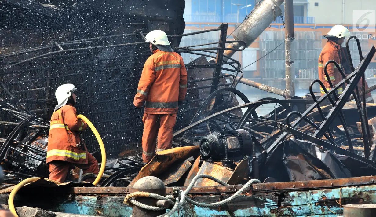 Petugas pemadam kebakaran melakukan pendinginan kapal yang ludes dilalap api di Pelabuhan Muara Baru, Jakarta, Minggu (24/2). Kebakaran diduga akibat korsleting yang dipicu oleh aktivitas pengelasan di KM Arta Minajaya. (Merdeka.com/Iqbal Nugroho)