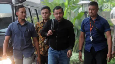 Ajudan Gubernur Aceh Irwandi Yusuf, Hendri Yusrizal (tengah) tiba di Gedung KPK, Jakarta, Rabu (4/7). Hendri tampak mengenakan jaket hitam sambil dikawal sejumlah petugas. (Merdeka.com/Dwi Narwoko)